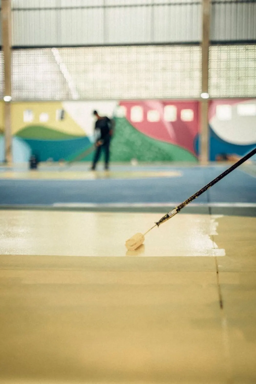 Nanošenje žutog epoksi premaza u sportskoj dvorani
